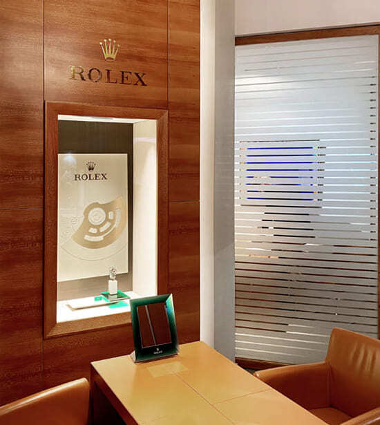 Der Rolex Showroom von Juwelier Freisfeld ist luxuriös eingerichtet mit Ledersesseln und Holzvertäfelung mit goldenem Rolex Zeichen