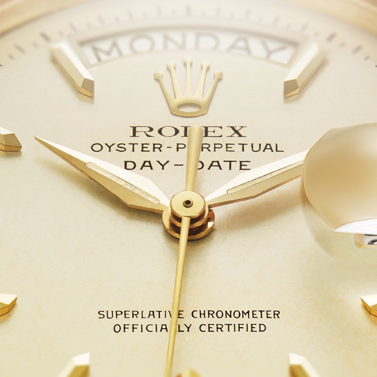 Helles Zifferblatt einer Rolex Oyster-Perpetual Day-Date mit goldenen Zeigern und Indizes.